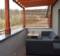 Balkon einer 2-Zimmer-Wohnung mit Holzdekor und Blick ins Grüne.