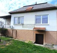 Ein Einfamilienhaus in Hráň mit einem Rasenhof, Fenstern und Eingangstüren.