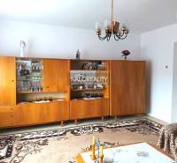 Wohnzimmer in einem Einfamilienhaus mit einer Wohnwand aus Holz und einem Kronleuchter.