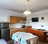 Eine Küche in einem Einfamilienhaus mit Holzkücheneinrichtung und Esstisch.