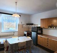 Küche in einem Einfamilienhaus mit Esstisch und Holzschränken.