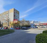 Wohnhaus und Einkaufszentrum in der Žehrianska-Straße in Bratislava V, mit Parkplatz und Autos.