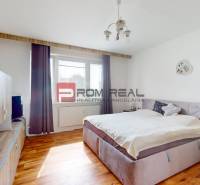 Ein Schlafzimmer in einer 4-Zimmer-Wohnung mit einem bequemen Bett und einem Boden in Holzoptik.