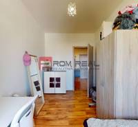 Ein Zimmer mit einem Schrank und einem Spiegel, ein Boden mit Holzdekor in einer 4-Zimmer-Wohnung.