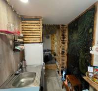 Küchenecke mit Holzdekorationen und Regalen, Boden mit Holzdekor.