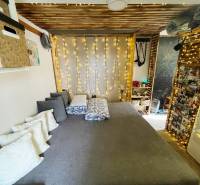 Interieur eines Einfamilienhauses mit Bett, Kissen und Lichtdekoration.