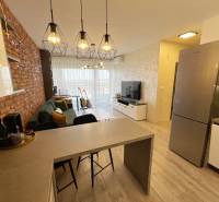 Wohnzimmer mit Bartresen, Holzboden und Ziegelakzent.