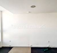 Weiße Wände mit einem großen Fenster und einem Holzboden in einem Büro.