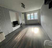 Wohnzimmer in einer 3-Zimmer-Wohnung mit Holzboden und Fernseher.