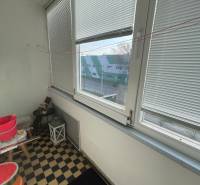 Ein verglaster Balkon mit Blick auf die Straße und einem Schachbrettboden in Hurbanovo.