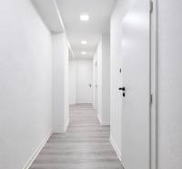 Ein Flur mit weißen Wänden und einem Boden in Holzoptik in einer 3-Zimmer-Wohnung.