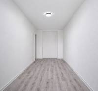 Ein enger Raum mit einem Boden in Holzoptik in einer 3-Zimmer-Wohnung.