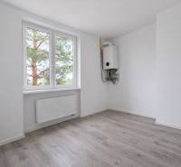 Ein Zimmer in einer 3-Zimmer-Wohnung mit einem Boden in Holzoptik und einem Heizkörper.