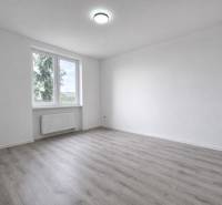 Geräumiges Zimmer mit Fenster und Holzboden in einer 3-Zimmer-Wohnung.