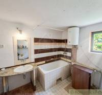 Badezimmer im Einfamilienhaus mit Waschbecken, Badewanne und Boiler.