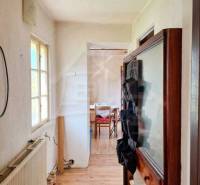 Interieur eines Einfamilienhauses mit einem schmalen Flur und einem Raum am Ende.