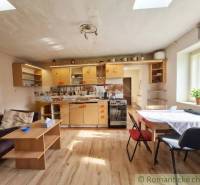 Küche in einem Einfamilienhaus mit Holzboden, hellem Interieur und einfachem Möbel.