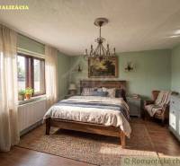 Schlafzimmer mit rustikalen Möbeln, Holzboden und großem Fenster in einem Einfamilienhaus.