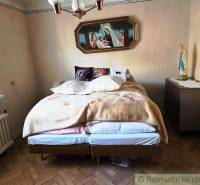 Ein Schlafzimmer in einem Einfamilienhaus mit einem Bett und religiöser Dekoration an der Wand.