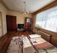 Ein Zimmer in einem Einfamilienhaus mit einem Bett, einem Schrank und einem Boden mit Holzdekor.