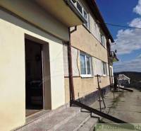 Ein Einfamilienhaus in Kiarov mit einer Treppe und großen Fenstern, in einer ländlichen Straße.