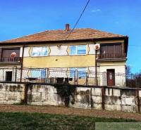 Ein Einfamilienhaus in Kiarov mit einer gemauerten Umzäunung und einer Satellitenschüssel.