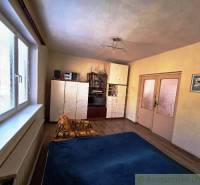 Ein Zimmer mit einem Holzboden, einem Bett, einem Schrank und einem dekorativen Bild in einem Einfamilienhaus.