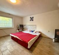 Schlafzimmer mit Herd, Fernseher und Bett, Boden mit Holzdekor.