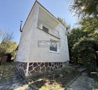 Ein Einfamilienhaus umgeben von Bäumen und Sträuchern in den Gärten der Stadt Rimavská Sobota.