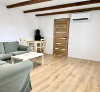 Wohnzimmer in einem Einfamilienhaus mit Holzbalken und einem Boden in Holzoptik.