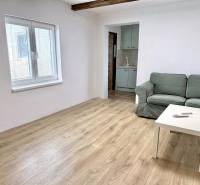 Wohnzimmer in einem Einfamilienhaus mit Sofa, Tisch und Holzboden.