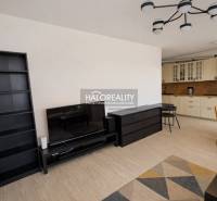 Wohnzimmer in einer Zweizimmerwohnung mit Küchenzeile und Holzboden.