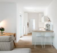 Küche mit Tisch, Sofa und Holzboden in einer 4-Zimmer-Wohnung.