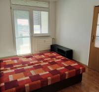 Schlafzimmer in einer 3-Zimmer-Wohnung mit einem Bett und einem Boden in Holzoptik.