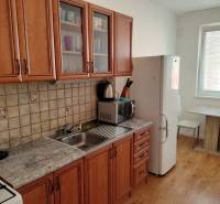 Küche in einer 3-Zimmer-Wohnung mit Holzboden und Holzmöbeln.