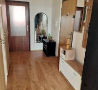 Der Flur einer 3-Zimmer-Wohnung mit Holzboden und einer Garderobenwand.