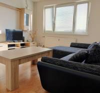 Wohnzimmer mit Sofa, Fernseher und Holzboden in einer 3-Zimmer-Wohnung.