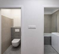 Fliesen im Badezimmer mit Waschmaschine und Toilette in einer 2-Zimmer-Wohnung.
