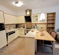 Küche in einer 2-Zimmer-Wohnung mit Esstisch und Boden in Holzoptik.