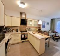 Küche in einer 2-Zimmer-Wohnung mit Kücheninsel und eingebauten Geräten.