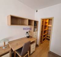 Ein Schreibtisch mit Stauraum in einer 2-Zimmer-Wohnung mit einem Boden in Holzoptik.