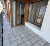 Balkon mit Fliesen und Holzdekor, Teil einer 2-Zimmer-Wohnung, mit Geländer und Aussicht.