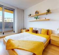 Schlafzimmer mit Zugang zur Terrasse, helle Möbel, Boden mit Holzdekor.
