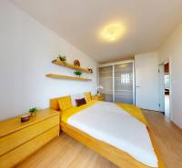 Schlafzimmer in einer 3-Zimmer-Wohnung mit Holzdekor und modernem Stauraum.