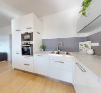 Küche in einer 3-Zimmer-Wohnung mit Holzboden, weißen Schränken und Geräten.