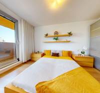 Schlafzimmer in einer 3-Zimmer-Wohnung mit Holzelementen und direktem Zugang zum Balkon.