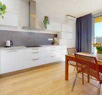 Küche in einer 3-Zimmer-Wohnung mit Holzboden und Esstisch.