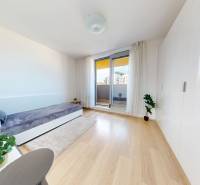 Helles Zimmer mit Bett, Einbauschrank und Boden mit Holzdekor in einer 3-Zimmer-Wohnung.