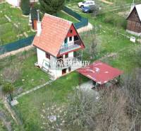 Ein Familienhaus und Gärten in Čachtice mit einer Pergola und umliegender Vegetation.