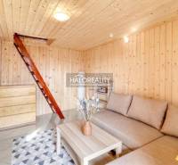 Ein Interieur mit einem Sofa, Treppen und Holzwänden in den Gärten.